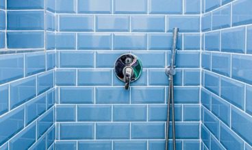 new shower tiled with blue subway tiles